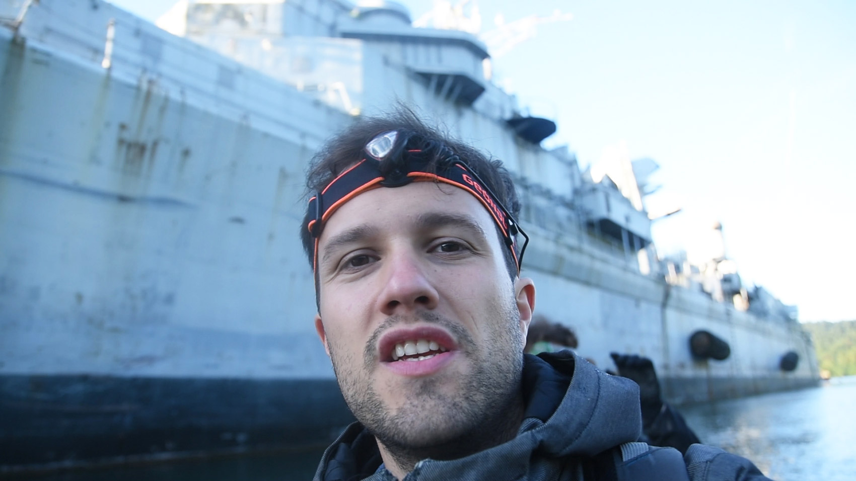 Florian Henn (Mamytwink) devant des navires de guerre désaffectés